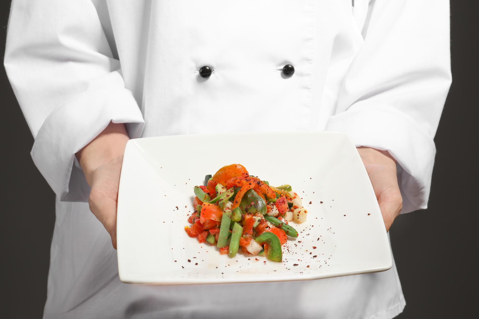 Chef che mostra un piatto in cucina